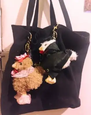 Dos GallinAsspas colgadas como llavero de una bolsa negra